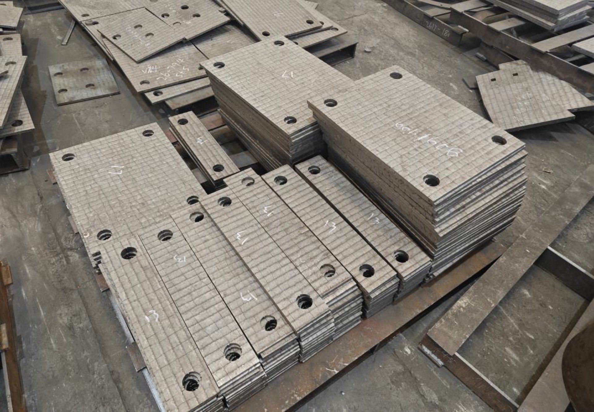 Batches of drilled wear liners stacked in the workshop